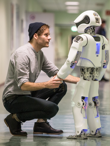 Bild: BHT Ein Mann und ein Roboter halten sich an den Händen uns sehen sich an